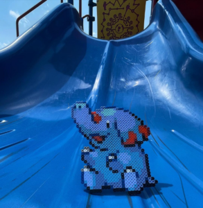 Pokémon Phanpy perler bead artwork positioned to look as if it is sliding down a blue slide.
